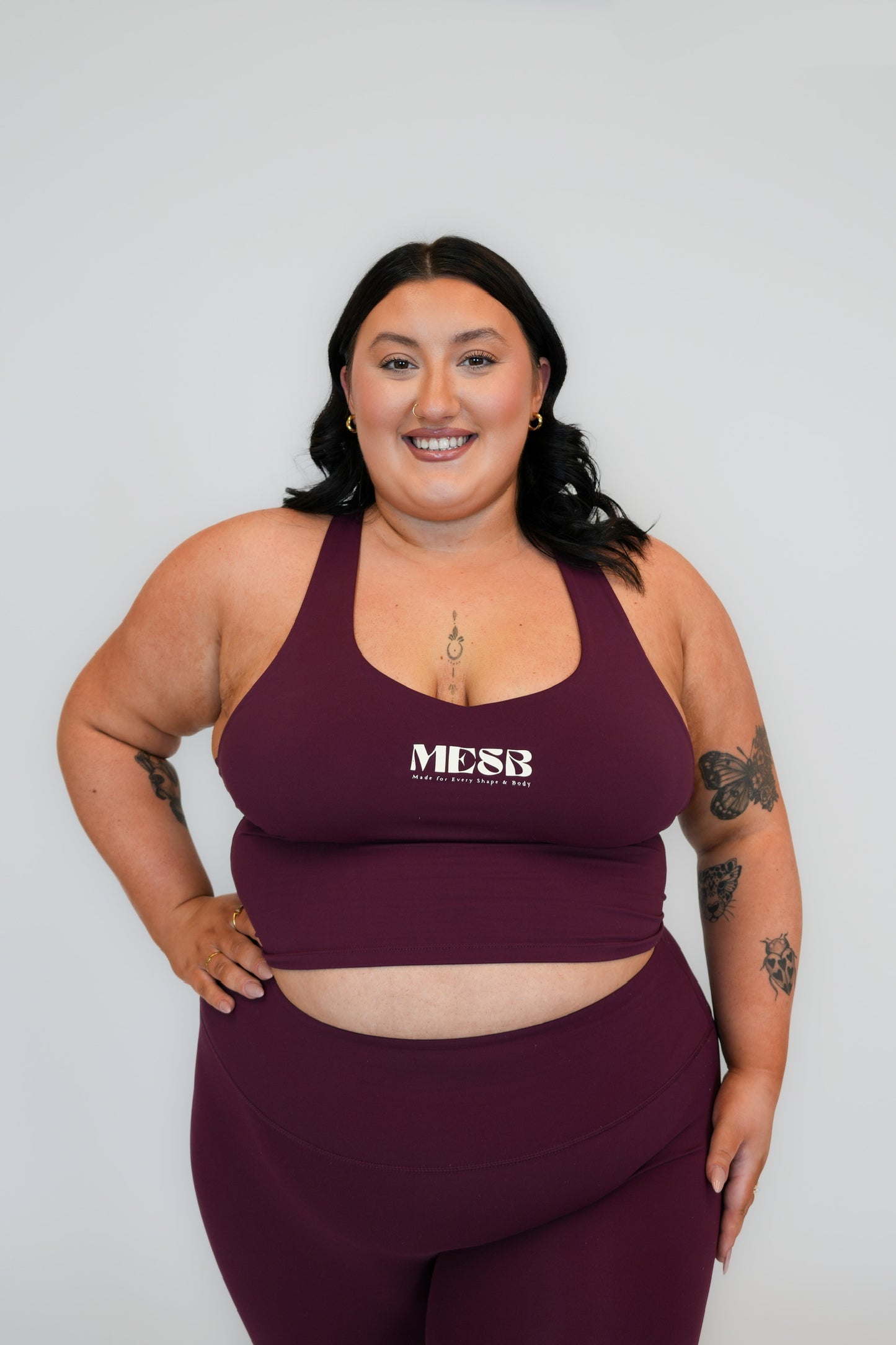 Close up of model wearing Garnet glow tank top MESB set with her hand on her hip